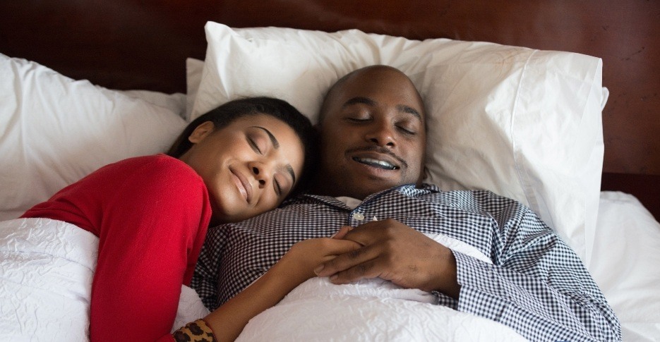 Man and woman in bed sleeping soundly thanks to snoring treatment