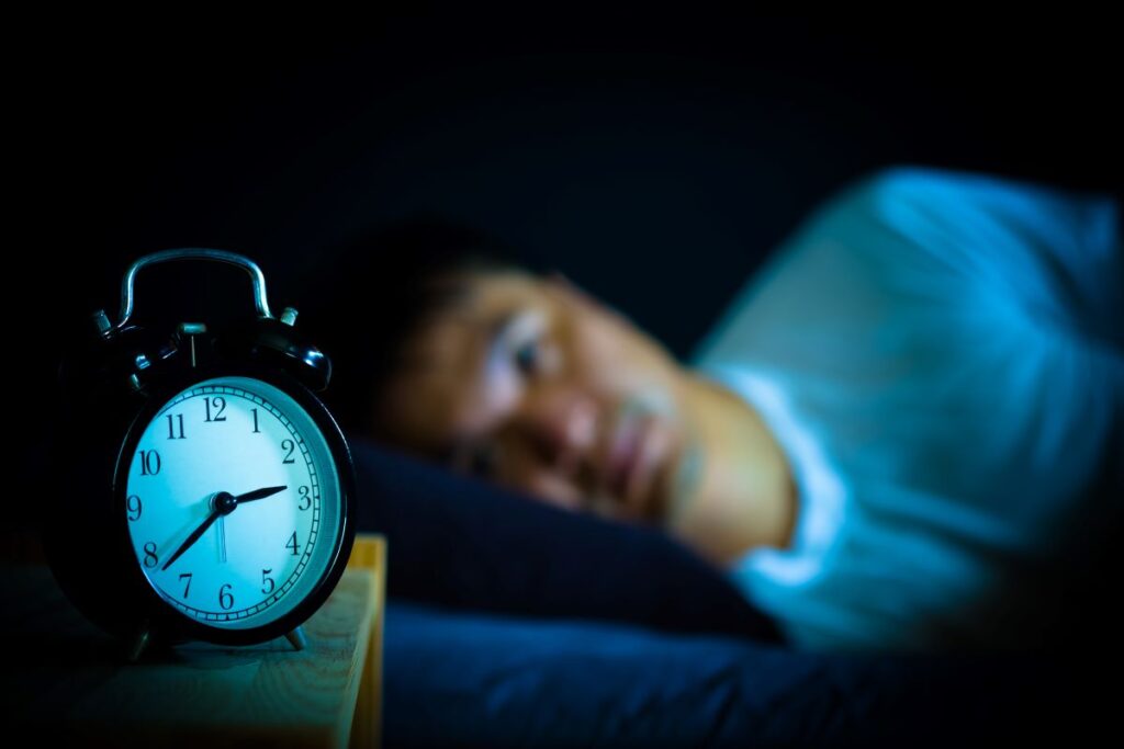 Man with sleep apnea lying awake worrying