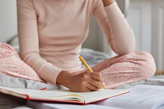 woman writing in sleep diary 