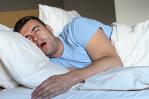 Man sleeping in bed with his mouth open